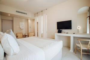 卡科佩特里亚Thymises Boutique Hotel的白色卧室配有一张大床和一张书桌