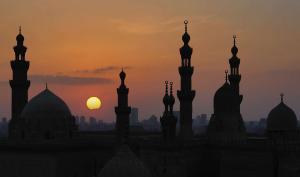 开罗开罗扎马雷克希尔顿酒店的一座清真寺的轮廓,背景是日落