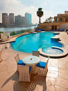开罗开罗扎马雷克希尔顿酒店的一个带椅子和桌子的景观游泳池