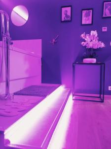 梅斯L'Atelier de rêves的紫色的浴室,桌子上放着花瓶