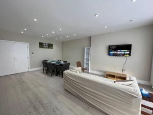 亨顿Star London Bell Lane 3-Bed Oasis with Garden的客厅配有白色的沙发和桌子