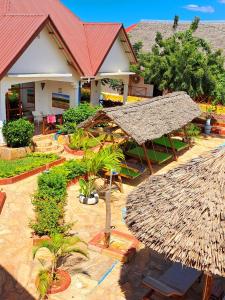 南威Mimi na wewe villa的拥有稻草屋顶的度假胜地