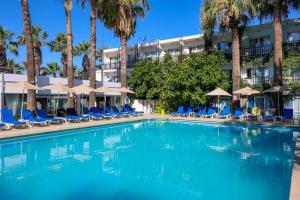 居姆贝特Sami Beach Hotel- All Inclusive的一个带椅子的游泳池,棕榈树