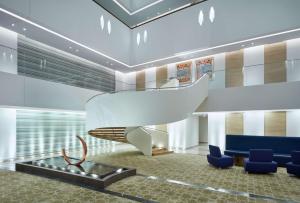 马斯喀特Hilton Garden Inn Muscat Al Khuwair的大堂设有楼梯和蓝色椅子
