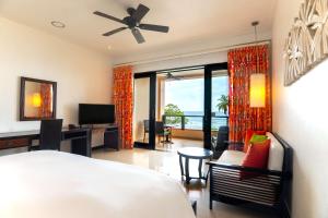 塔卡马卡塞舌尔阿拉曼达希尔顿逸林酒店及水疗中心的一间卧室配有一张床、一张书桌和一台电视