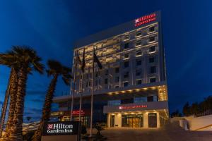 卡萨布兰卡Hilton Garden Inn Casablanca Sud的一座楼前有棕榈树的酒店