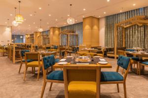 卡萨布兰卡Hilton Garden Inn Casablanca Sud的用餐室配有桌椅和吊灯。