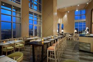 阿可贺巴Hilton Garden Inn Al Khobar的餐厅设有桌椅和大窗户。