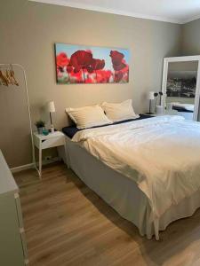 特隆赫姆Bakklandets Perle 3-roms的卧室配有一张床,墙上挂有绘画作品