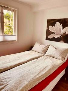 特隆赫姆Bakklandets Perle 3-roms的卧室内的两张床,墙上挂着一幅花画
