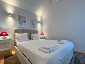 波尔图Nomads Lux - 2BDR Almada Private Porto的卧室配有带毛巾的大型白色床