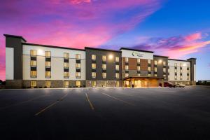 东兰辛WoodSpring Suites East Lansing - University Area的一座大型建筑,前面设有停车场