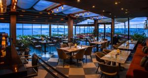 伊斯坦布尔伊斯坦布尔莫达希尔顿逸林酒店 的餐厅设有桌椅和窗户。