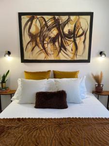 奥德赛克斯stressfree charm house的卧室配有一张白色床,墙上挂有绘画作品