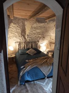 蒙索罗Gite des Perreyeurs - maison troglodyte avec vue sur Loire的卧室配有一张石墙床