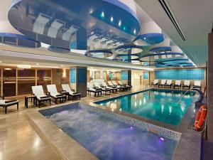 阿瓦诺斯阿凡诺斯卡帕多西亚希尔顿逸林酒店的酒店的大型游泳池配有桌椅