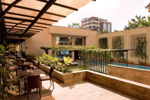 内罗毕内罗毕希尔顿逸林酒店 的一个带桌椅的户外庭院和一个游泳池