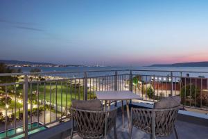 恰纳卡莱Doubletree By Hilton Canakkale的一个带桌椅的海景阳台