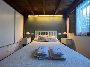 马塔埃尔皮诺Acogedora casa rural en la sierra de Madrid的一间卧室配有一张大床和毛巾