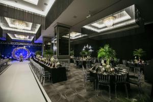 伊兹密尔伊兹密尔机场希尔顿逸林酒店的宴会厅配有桌椅和吊灯