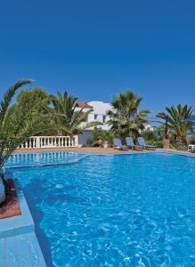 特尔桑纳斯特尔桑纳斯乡村公寓酒店的一个带椅子和棕榈树的大型游泳池