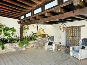 纳萨雷特Villa Nazoly的庭院设有白色椅子和木制天花板。