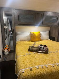 德兰Your Personal 'Glamp' Site! AC - BBQ - Fast WiFi的一间卧室配有一张黄色的床,上面有摄像头