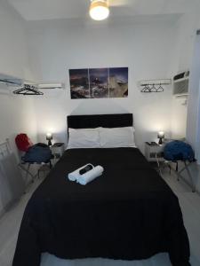 里约热内卢Studio Leblon的一间卧室配有一张带黑色棉被的床和两把椅子