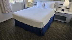里诺Club Lakeridge的一张大床,位于酒店客房内,配有白色床罩