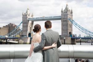 伦敦希尔顿伦敦塔桥酒店的站在塔桥前面的新娘和新郎