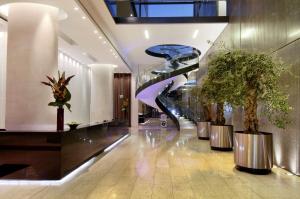 曼彻斯特希尔顿曼切斯特丁斯盖特酒店的大堂设有螺旋楼梯和盆栽植物