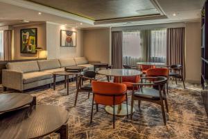 沃特福德Hilton London Watford的酒店客房配有桌椅和沙发。