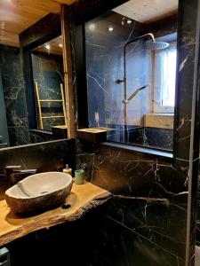 热拉梅Maison Les Planches的一间带石制水槽和镜子的浴室