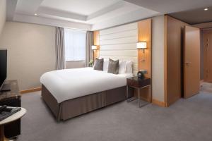 伦敦伦敦圣詹姆斯康拉德酒店的酒店客房设有一张大床和一台电视。