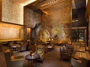 北京北京康莱德酒店 - 希尔顿集团的一间带桌椅的餐厅以及一堵树墙