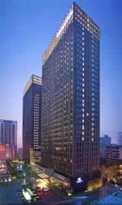 重庆重庆江北希尔顿逸林酒店的一座高大的建筑,城市里有很多窗户