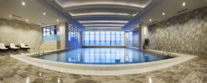 重庆重庆江北希尔顿逸林酒店的一座带大堂的大楼内的大型游泳池