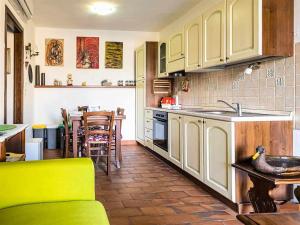 卡斯蒂里昂纳·德拉佩La Casina di Rosi vivere nellantico borgo的厨房配有白色橱柜、桌子和柜台。