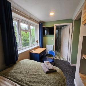 ScorrierGoonearl Simply Stay的一间卧室配有一张床、一张书桌和窗户。