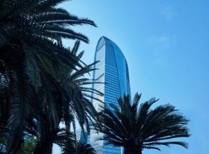 海口海口希尔顿酒店的一座高大的建筑,前面有棕榈树