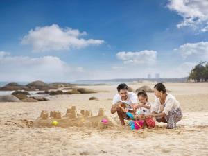 文昌文昌鲁能希尔顿酒店的家庭在沙滩上玩沙堡