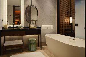 杭州杭州金沙湖和达希尔顿嘉悦里酒店的带浴缸、水槽和镜子的浴室
