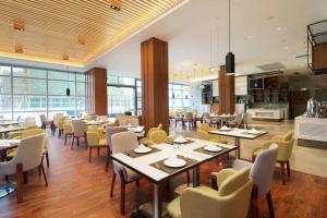 珠海珠海横琴希尔顿花园酒店的一间带桌椅的餐厅和一间厨房