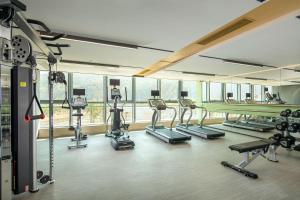 珠海珠海横琴星乐度希尔顿花园酒店的一间健身房,里面配有数台跑步机和机器