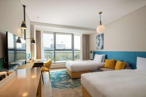 珠海珠海横琴星乐度希尔顿花园酒店的酒店客房,设有两张床和一张沙发