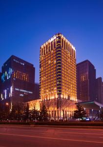 南京南京希尔顿酒店的一座高大的建筑,晚上有灯