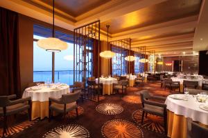 南京南京世茂滨江希尔顿酒店的餐厅设有桌椅和大窗户。