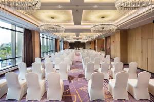 上海上海新虹桥国家会展中心灿辉希尔顿花园酒店的一间会议室,配有白色椅子和吊灯