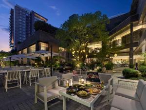上海上海虹桥祥源希尔顿酒店的庭院配有椅子和桌子,上面有食物