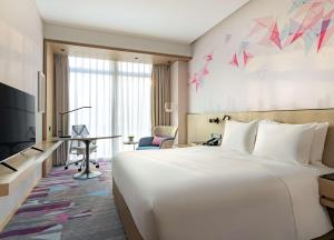 深圳深圳国际会展中心希尔顿花园酒店的酒店客房设有一张白色大床和一张书桌